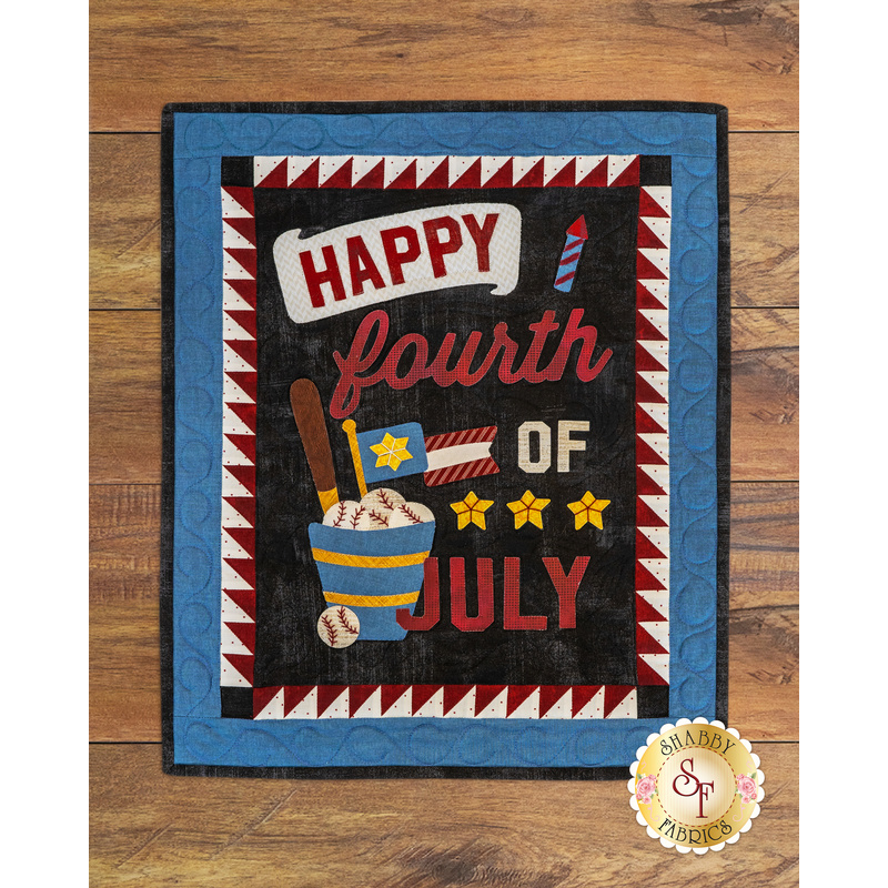 A decorative rug featuring the text Happy Fourth of July in bold colors, accompanied by graphics of baseballs, a bat, and star symbols, all set against a patterned background.