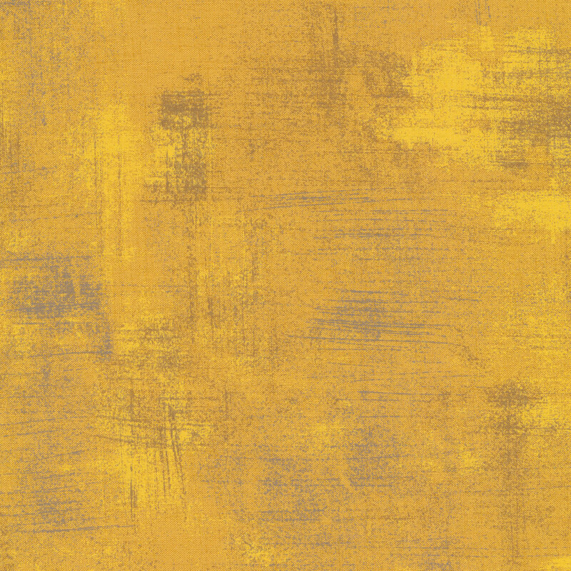 A golden yellow fabric with bits of brown grunge texturing