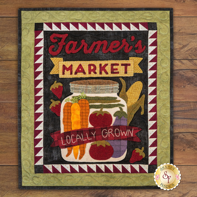 A colorful textile design featuring the words Farmer's Market at the top, a jar filled with vegetables, and a banner that reads Locally Grown. The background has a decorative border with triangular patterns.