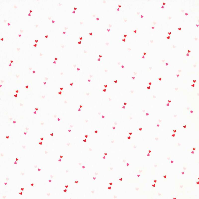 white fabric with pairs of tiny pink and red hearts scattered all over