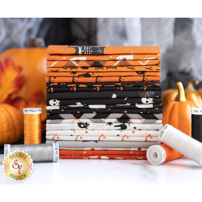 A stack of orange, black, white, and grey fabric rolls, featuring Halloween-themed patterns like ghosts, skeletons, and pumpkins, with spools of thread in coordinating colors placed nearby.