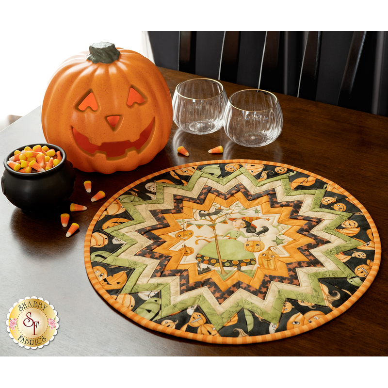 Folded star table topper with whimsical halloween prints in orange, cream, and green.