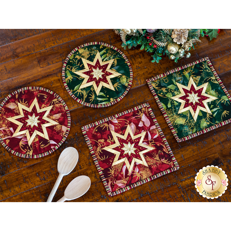 A set of 4 Stof Christmas folded star hot pads, one red and one green in a square and circle