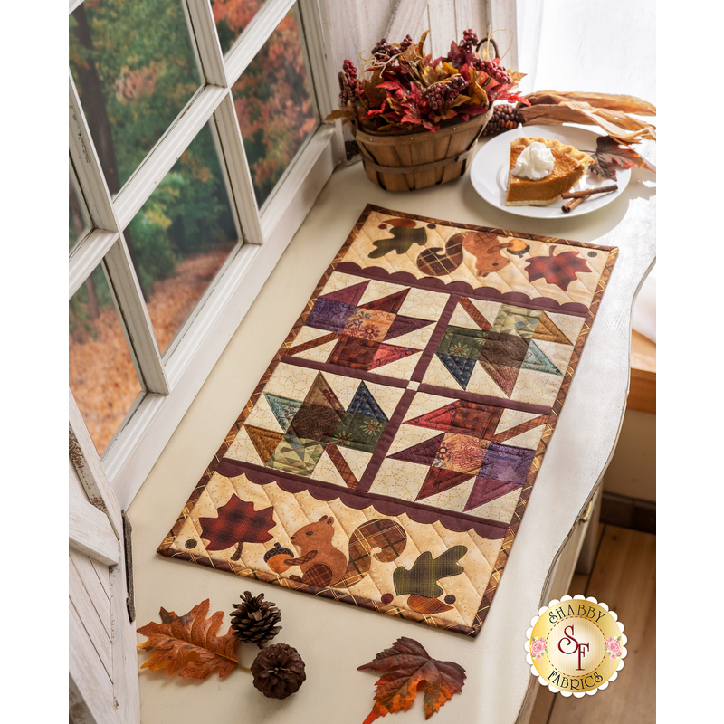 Pint Size Table Runner featuring leaf like geometric piecing and squirrel and leaf appliqué.