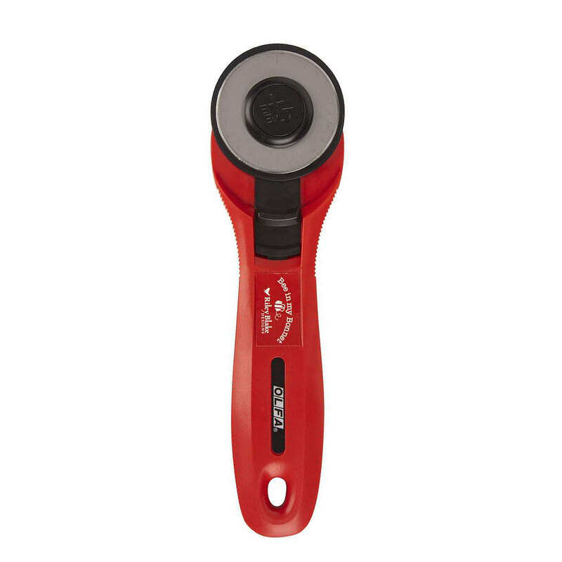 A red rotary fabric cutter with a circular blade and ergonomic handle.