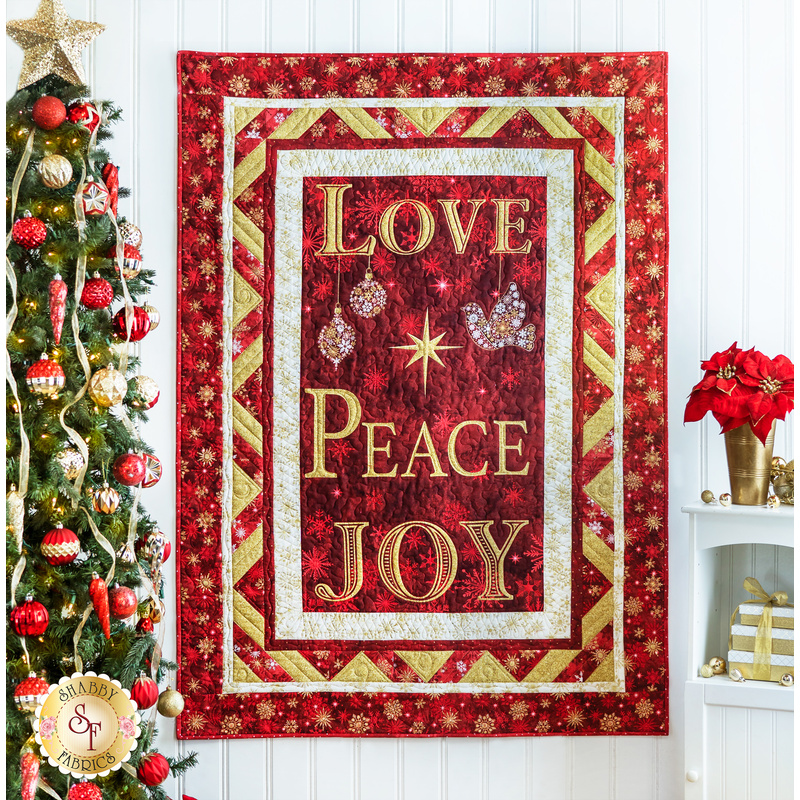 Christmas Joy Quilt Kit featuring the words Love, Peace, and Joy on red and gold fabric.