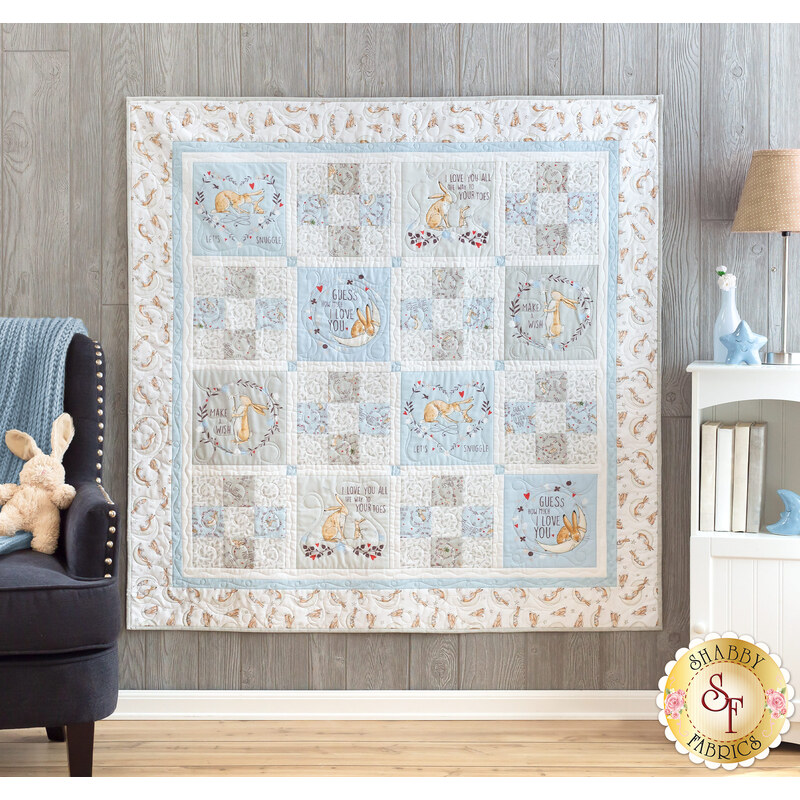 Photo of a cream, blue, and grey quilt that features rabbits from the children's book, 