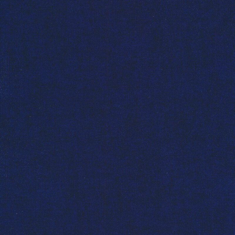 Solid tonal dark blue fabric with mottling all over