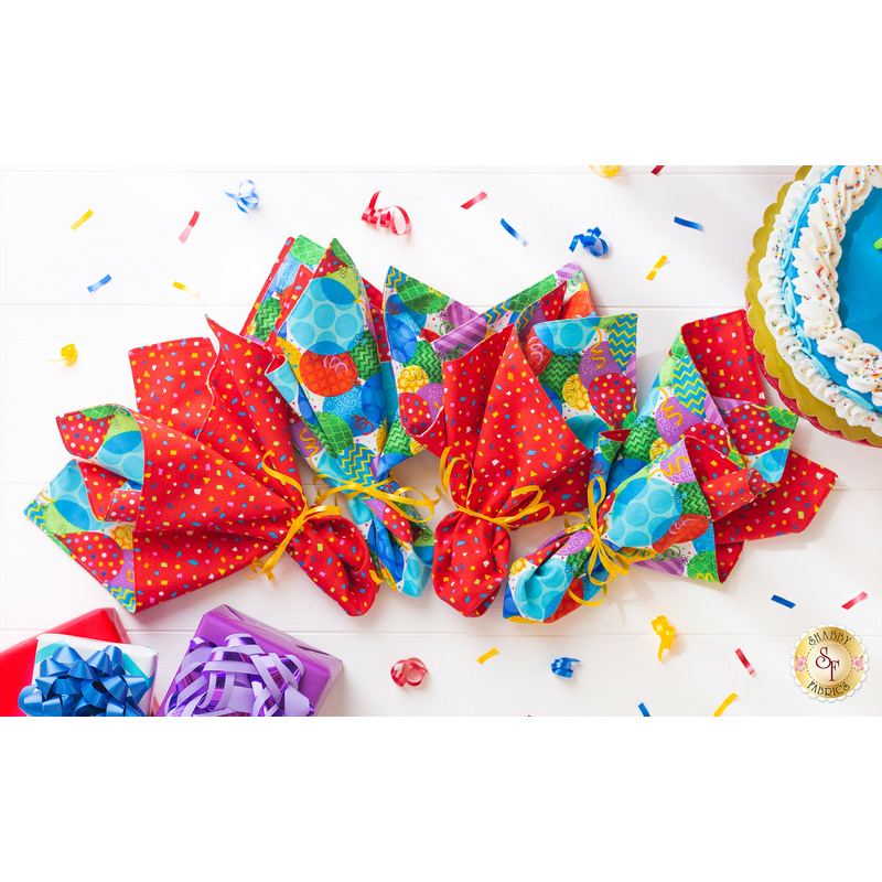 An image of four Party Time Cloth Napkins on a white table.