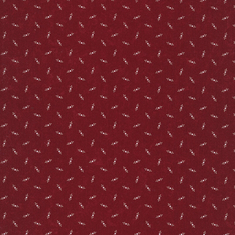 Fabric that features tossed cream motifs on a mottled maroon red background.