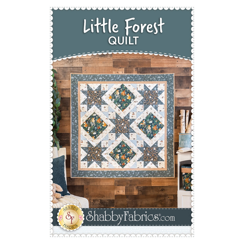 Photo of finished Little Forest Quilt hanging on a wood paneled wall with the title, 