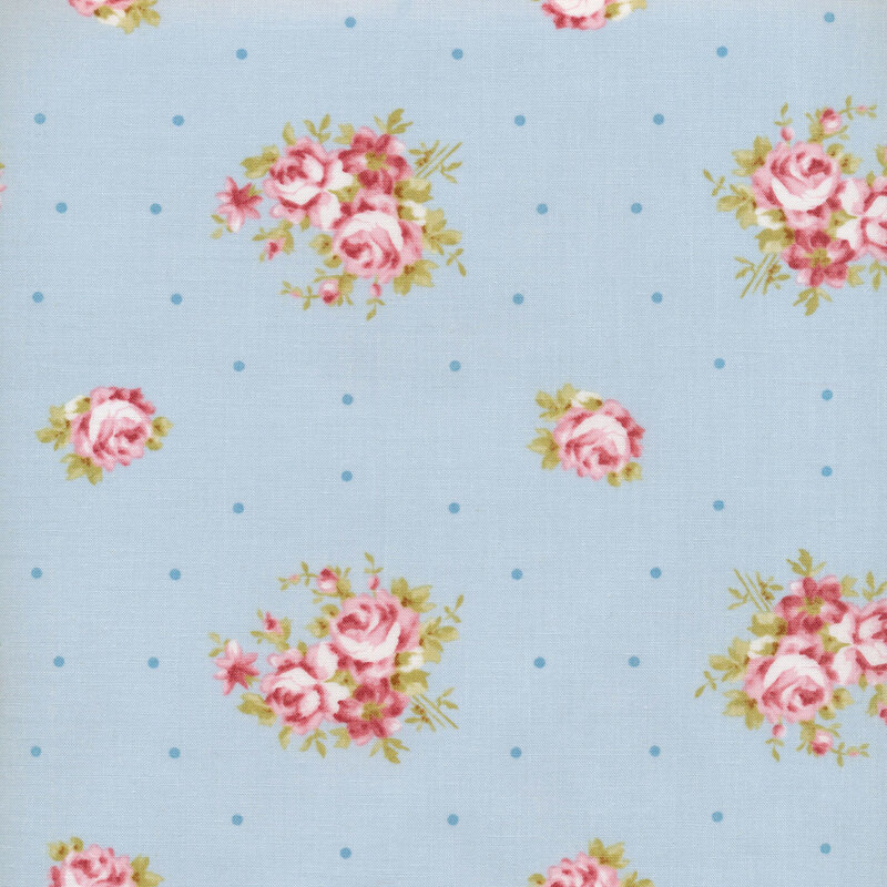 Image of fabric featuring arrangements of pink flowers and roses, interspersed with blue dots, on a lighter blue background