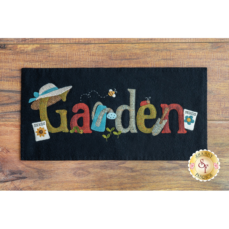 black rectangular table mat on a brown wooden countertop with the word 