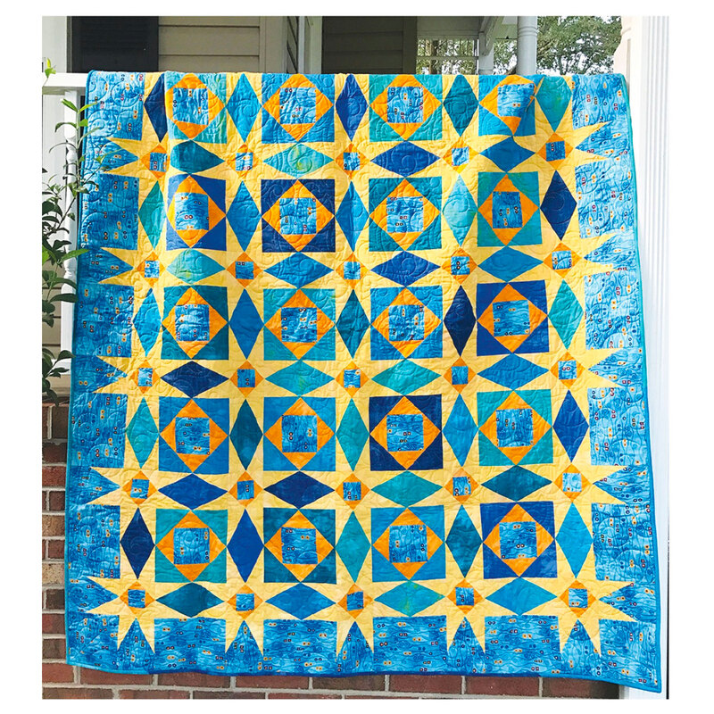 Image of a blue quilt with yellow ohio star piecing 