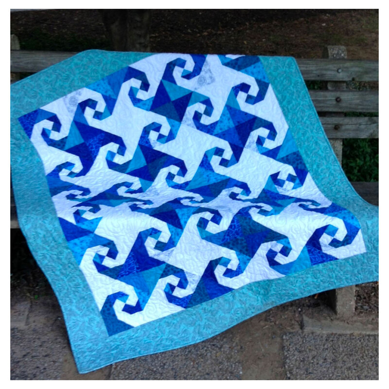 Image of a blue and white quilt with snail blocks on it