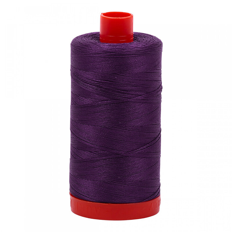 A spool of Aurifil 4225 - Eggplant thread on a white background