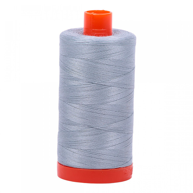 A spool of Aurifil 2612 -Arctic Sky thread on a white background