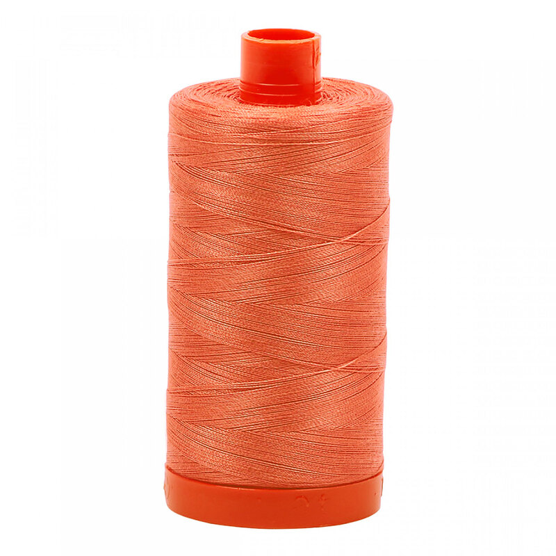 A spool of Aurifil 2225 -Salmon thread on a white background