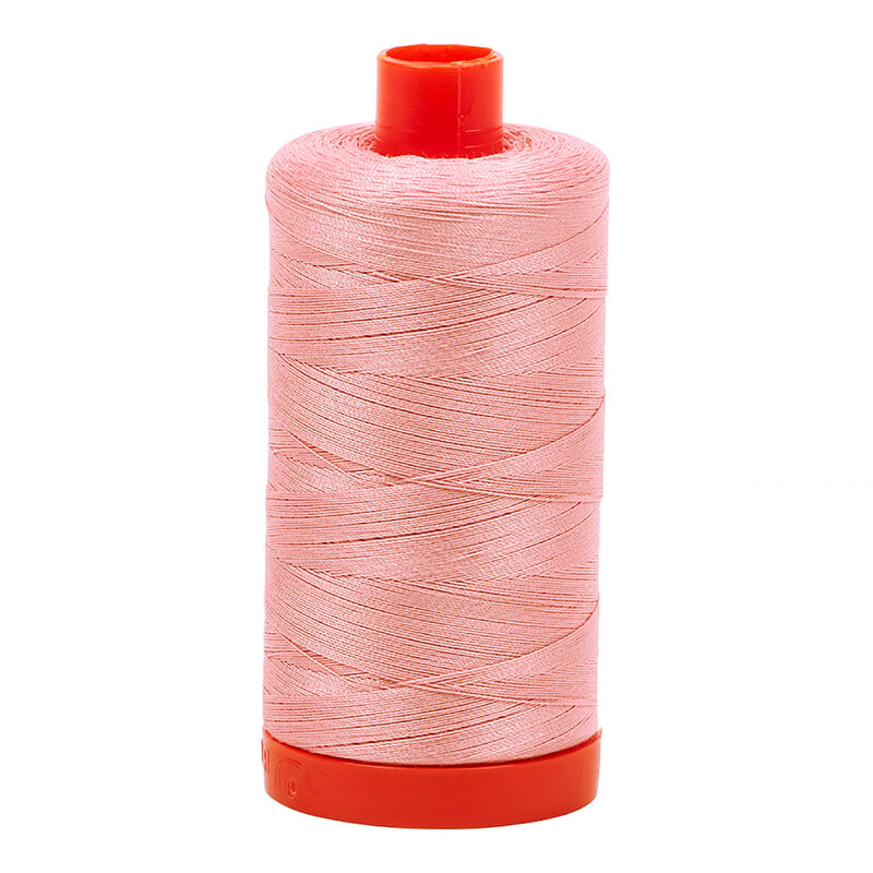 A spool of Aurifil 2437 - Light Peony thread on a white background