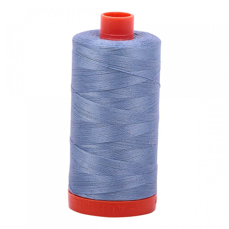 A spool of Aurifil 6720 - Slate thread on a white background