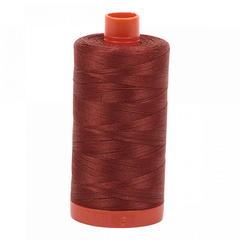 A spool of Aurifil 2355 - Rust thread on a white background