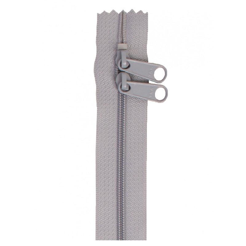 Photo of a gray zipper with two pull tabs isolated on a white background