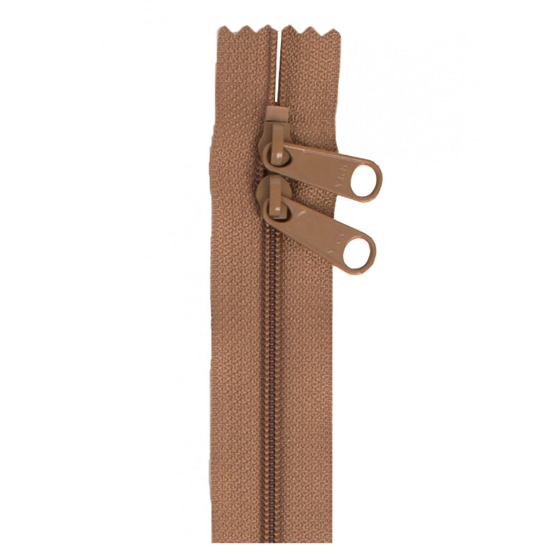 Photo of a brown zipper with two pull tabs isolated on a white background