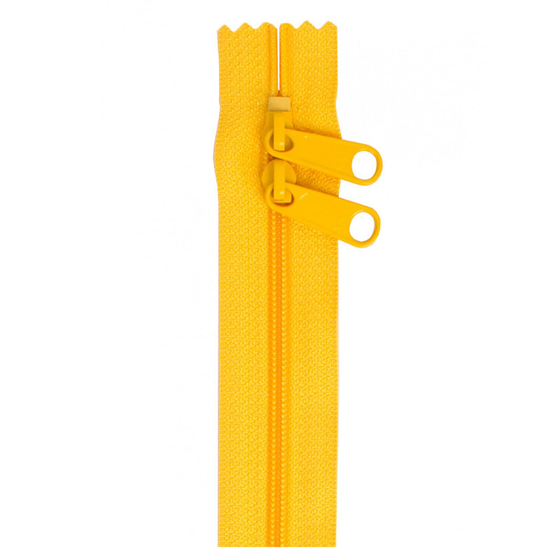 Photo of a yellow zipper with two pull tabs isolated on a white background