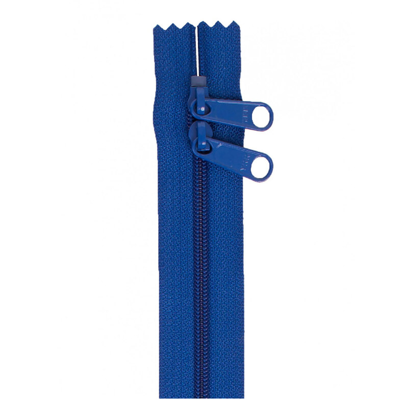 Photo of a dark blue zipper with two pull tabs isolated on a white background