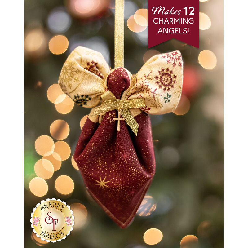 Close up photo of a pocket angel ornament made with the Stof Christmas 2023 fabric collection with a decorated and lit tree in the background and a banner that reads 