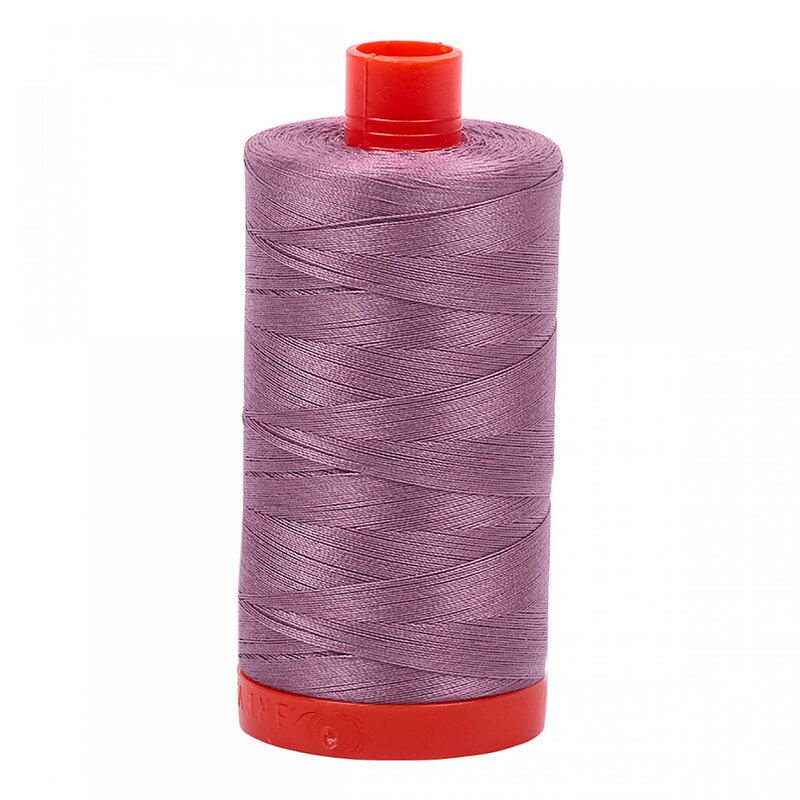 A spool of Aurifil 2566 - Wisteria thread on a white background