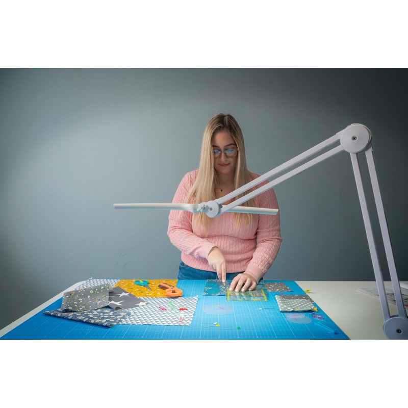 Woman using Lumi Task Lamp for a sewing project