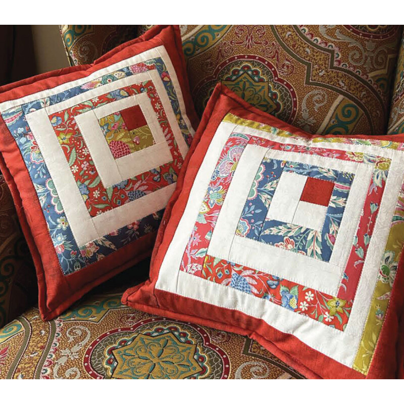 Two finished pillows staged on a big comfy chair with intricate details