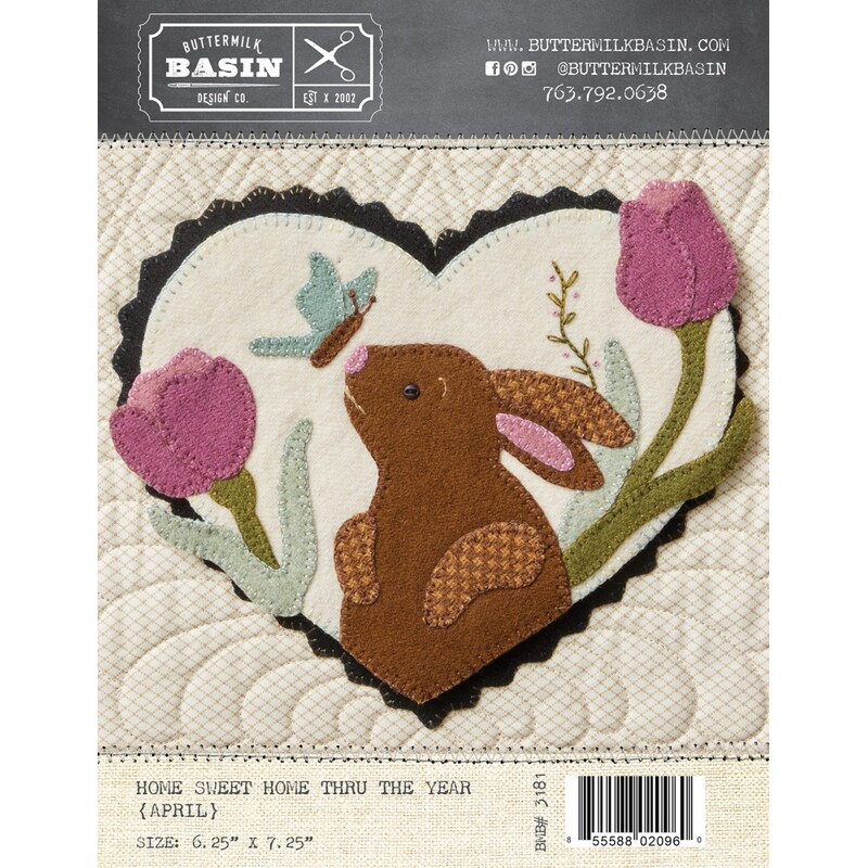 Front of pattern with finished heart featuring a woolen butterfly about to land on the bunny's nose, framed with flowers, so sweet and cute