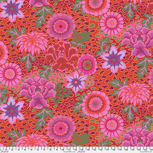 Fabric featuring vibrant pink, red, and purple flowers over a red and pink background with abstract green and maroon dots