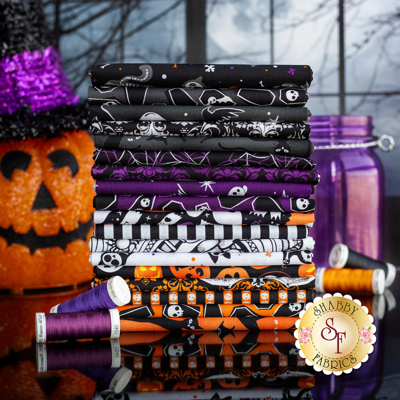 A photo of Halloween fabrics in lights out in shades of purple, orange black and white of halloween designs and patterns