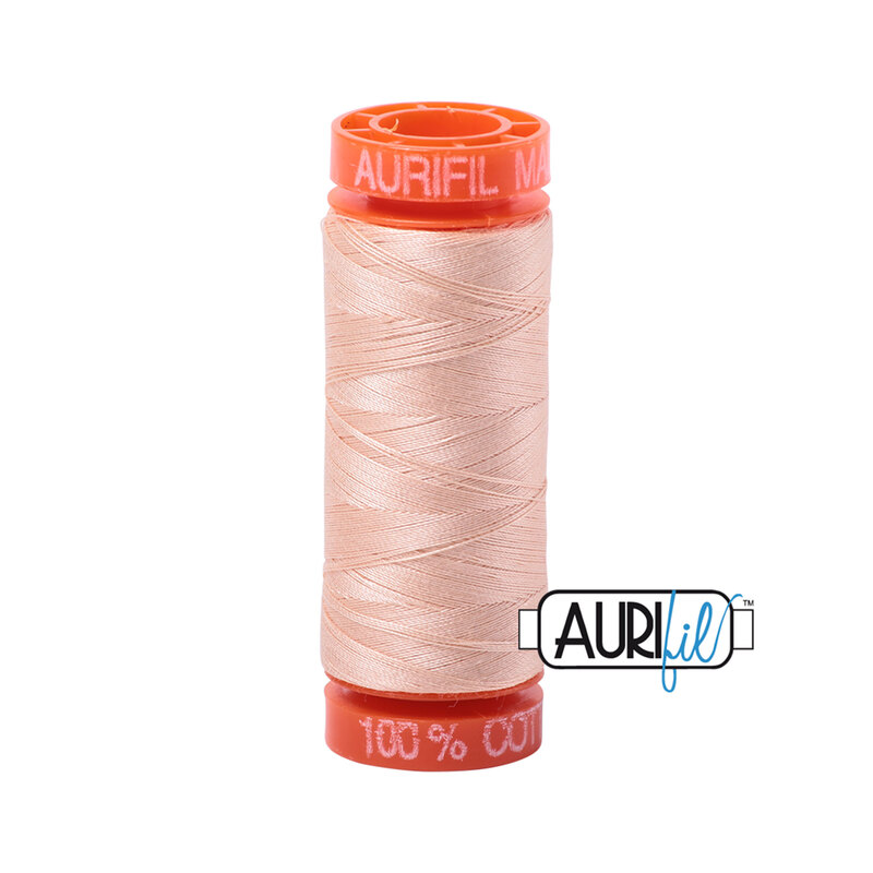 Flesh colored thread on an orange spool, isolated on a white background