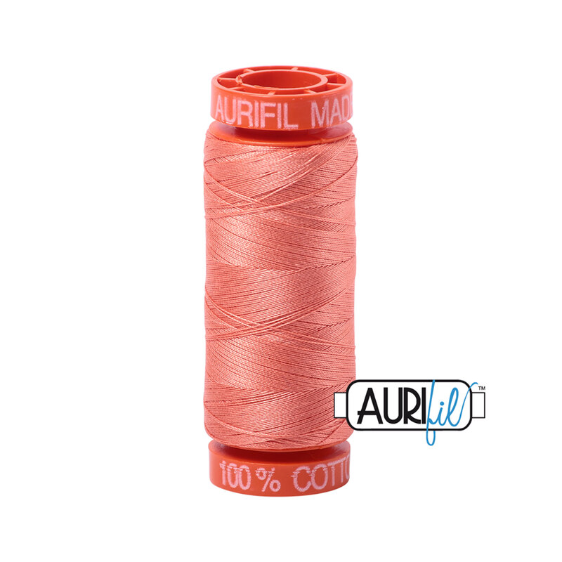 Light Salmon thread on an orange spool, isolated on a white background