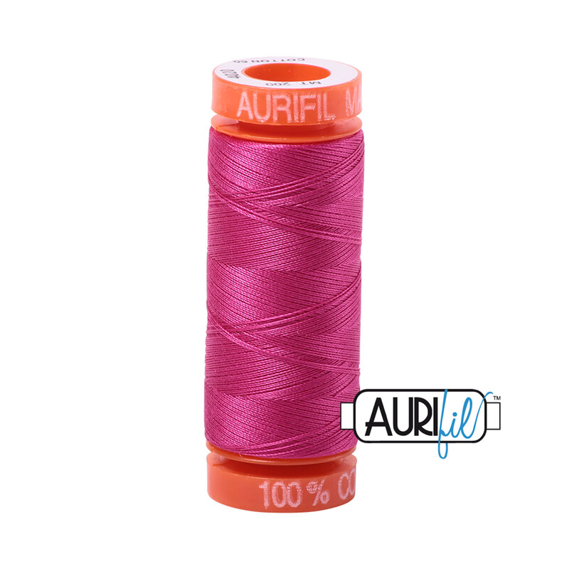 Fuchsia thread on an orange spool, isolated on a white background