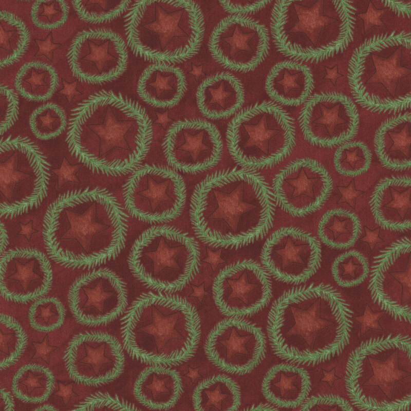 rich cranberry red fabric featuring scattered red stars with fir wreaths surrounding them