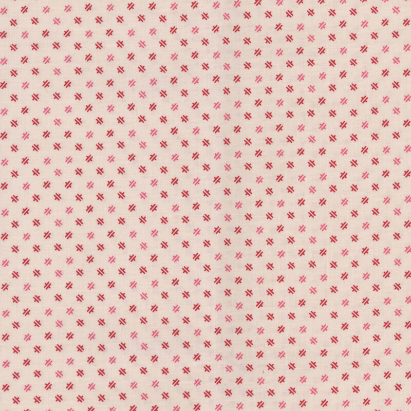 Latte fabric with a ditsy geometric red pattern.