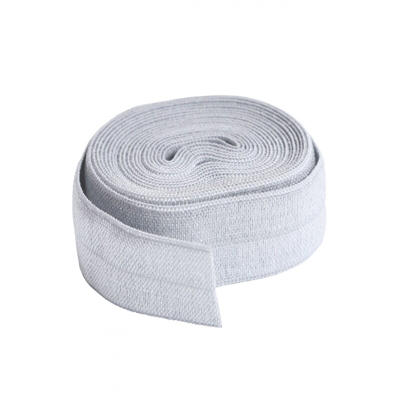 A circular roll of off white elastic, 3/4