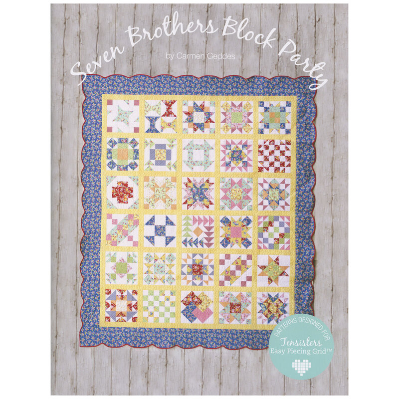 Front of pattern book showing an album quilt in yellow with blue borders, staged on white rustic wood paneling