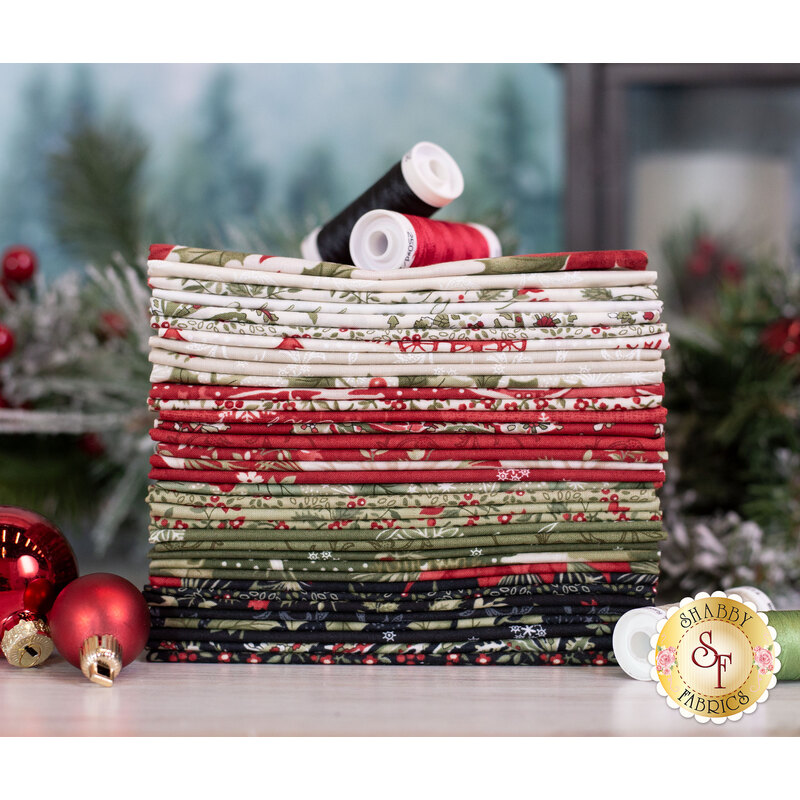 a stack of christmas fabrics in muted shades of red, green, cream, and black