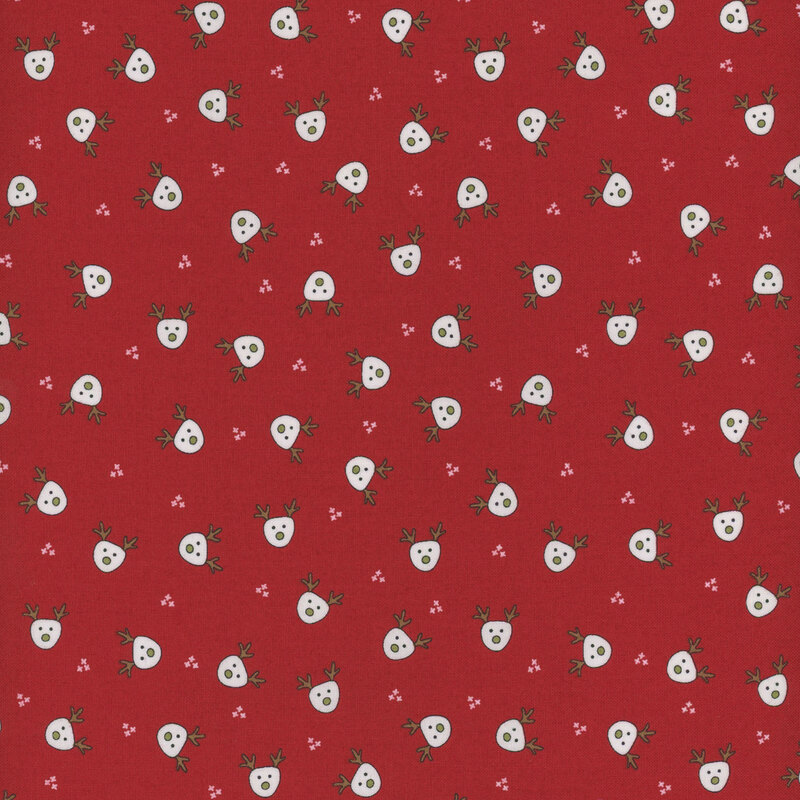 Red fabric featuring small white illustrated reindeer heads evenly spaced and tossed all over.