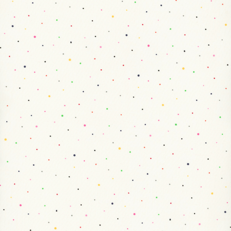 cream fabric with small scattered vibrant pink, red, yellow, green, black, and gray dots