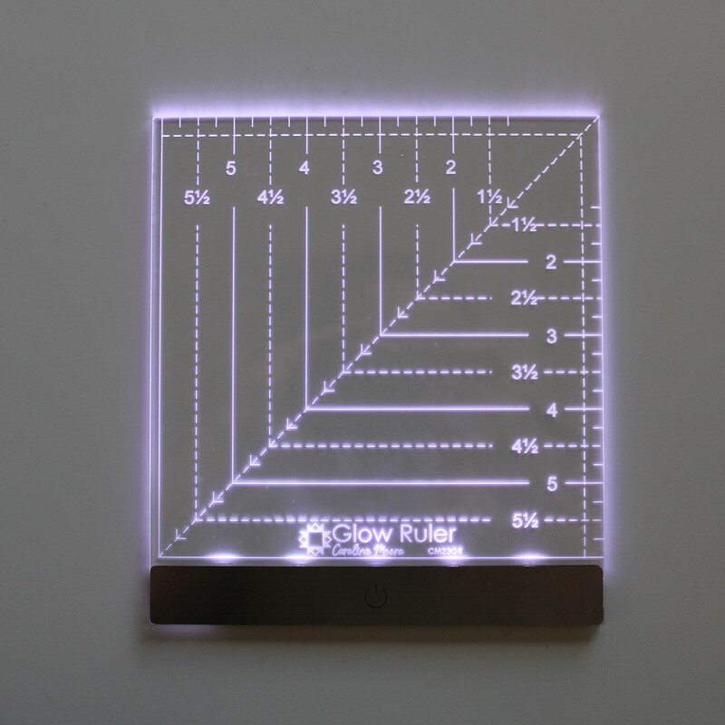 The glow ruler with the lights on, staged on a dark background to show the luminosity of the ruler.