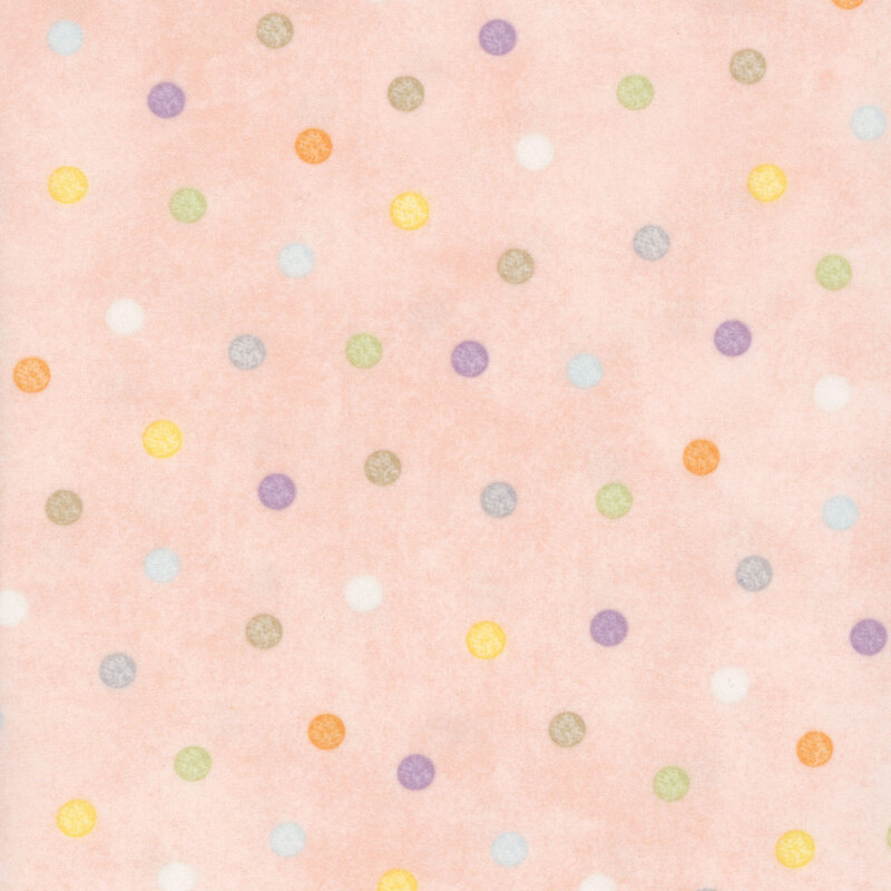 soft pastel pink fabric featuring pastel multicolored polka dots.