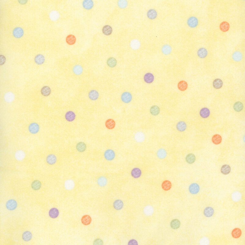 soft pastel yellow fabric featuring pastel multicolored polka dots.