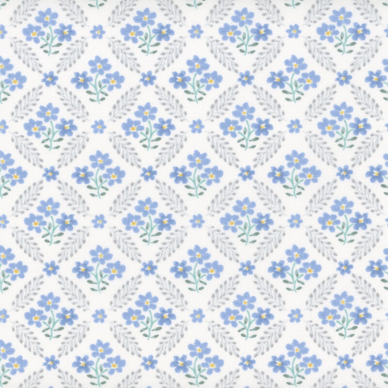 White fabric with a repeated leaf chain-link pattern with little blue floral clusters in between each section.